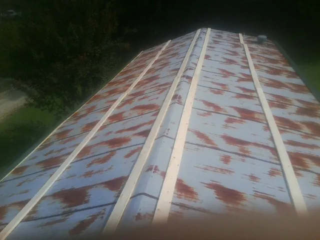 Rusted metal roof panels with new wood purlins before replacement — Storm Damage Roof Repair in Mason by Roofing Brothers