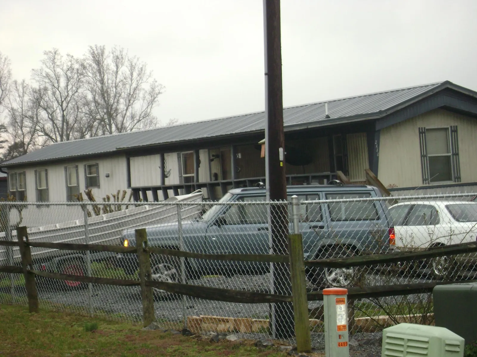 Dark metal roof on a long single story building behind a chain link fence in Mason